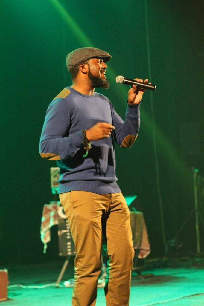 Ahmad Ikhlas performing under green stage lights